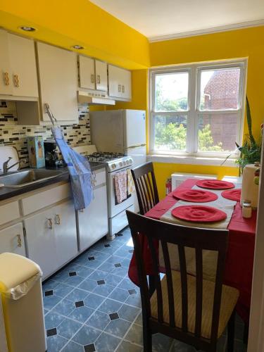 a kitchen with a table with red plates on it at Cheerful 2 BED ROOMS Apartment in heart of Queens in Jackson Heights