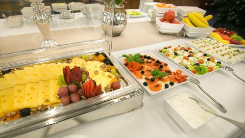 a buffet table with several trays of food on it at Hotel HP Park Poznań Malta in Poznań