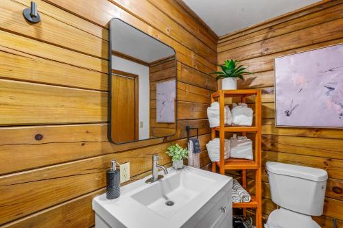 a bathroom with a white sink and a mirror at Couples Getaway Cabin near National Park w Hot Tub in Pigeon Forge