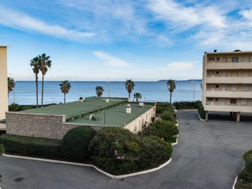 un bâtiment avec un court de tennis en face de l'océan dans l'établissement Studio au Lavandou, à 20m de la plage avec parking - FR-1-803-78, au Lavandou