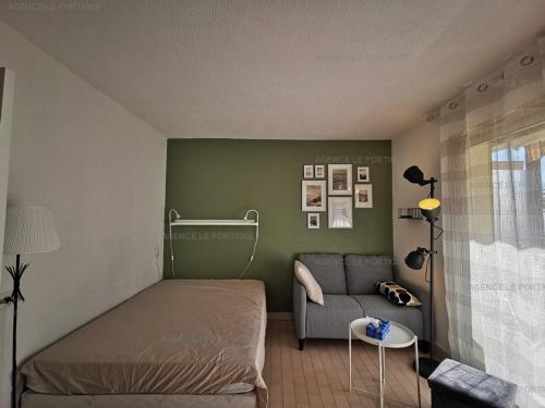 une petite chambre avec un lit et un canapé dans l'établissement Studio 4 personnes en bord de mer au Lavandou avec parking - FR-1-803-89, au Lavandou