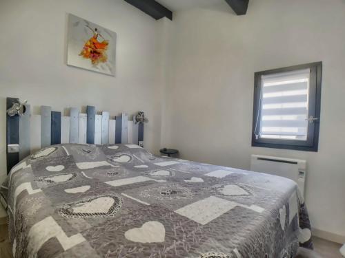 une chambre avec un lit avec une couette dessus dans l'établissement Appartement 8 pers. avec terrasse, proche centre - FR-1-475-157, à Saintes-Maries-de-la-Mer