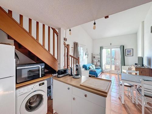 une cuisine avec un lave-linge et un sèche-linge sur un comptoir dans l'établissement Appartement proche mer, parking, animaux acceptés - FR-1-475-159, à Saintes-Maries-de-la-Mer
