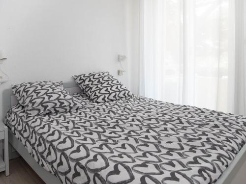 - un lit avec une couette et des oreillers en noir et blanc dans l'établissement Le Lavandou : T2 + cabine, clim, parking, accès plage - FR-1-803-88, au Lavandou
