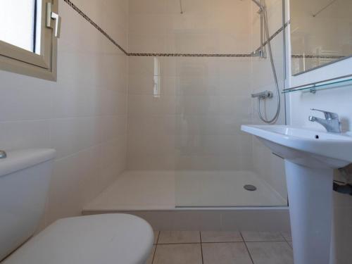 une salle de bain blanche avec un lavabo et une douche dans l'établissement Le Lavandou : T2 + cabine, clim, parking, accès plage - FR-1-803-88, au Lavandou