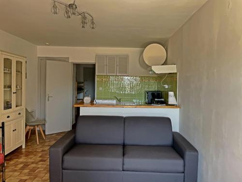 un salon avec un canapé et une cuisine dans l'établissement Studio climatisé avec parking à 800 m de la mer - FR-1-475-164, à Saintes-Maries-de-la-Mer