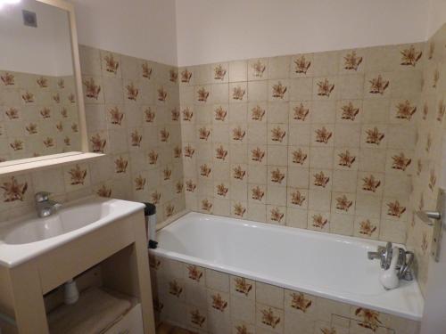 une salle de bain avec une baignoire blanche et un lavabo dans l'établissement Studio climatisé avec parking à 800 m de la mer - FR-1-475-164, à Saintes-Maries-de-la-Mer