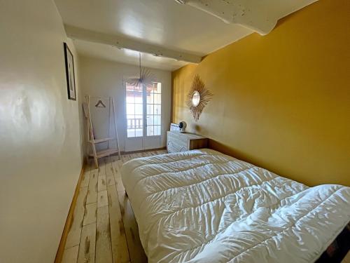 sypialnia z łóżkiem i żółtą ścianą w obiekcie Maison 6 personnes avec cheminée aux Saintes-Maries-de-la-Mer - FR-1-475-162 w Saintes-Maries-de-la-Mer