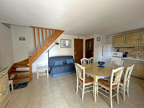 une cuisine et une salle à manger avec une table et des chaises dans l'établissement Maison 6 pers avec piscine commune et climatisation - FR-1-475-166, à Saintes-Maries-de-la-Mer