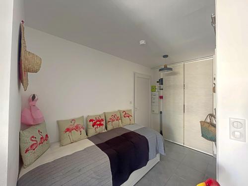 a bedroom with a bed with red flowers on it at Studio 3 pers proche mer avec parking et climatisation - FR-1-475-165 in Saintes-Maries-de-la-Mer