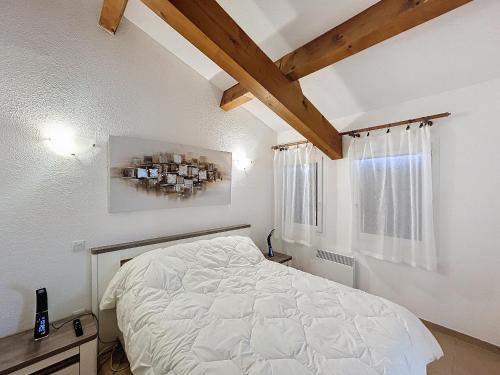 une chambre avec un lit blanc et une fenêtre dans l'établissement Appartement 2 pièces proche centre, clim, terrasse - FR-1-475-169, à Saintes-Maries-de-la-Mer