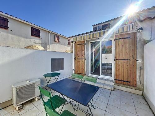 un patio avec une table et des chaises sur un balcon dans l'établissement Appartement 2 pièces proche centre, clim, terrasse - FR-1-475-169, à Saintes-Maries-de-la-Mer