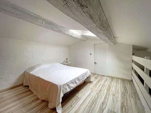 une chambre blanche avec un lit et un parquet dans l'établissement Maison avec piscine et parking en Camargue - FR-1-475-171, à Saintes-Maries-de-la-Mer