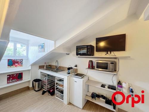 une cuisine avec un évier et un micro-ondes dans l'établissement Studio charmant, climatisé, dans un ancien palace à Menton - FR-1-647-45, à Menton