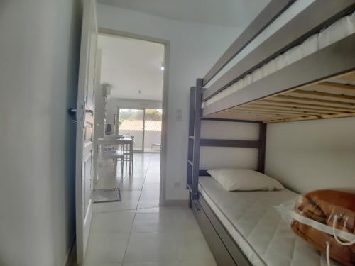 a bedroom with a bunk bed and a dining room at Studio 4 pers climatisé avec parking, à 100m de la mer - FR-1-475-174 in Saintes-Maries-de-la-Mer