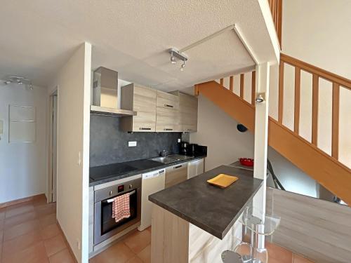 une cuisine avec une cuisinière et un comptoir dans l'établissement Appartement cosy avec climatisation et parking aux Saintes-Maries-de-la-Mer - FR-1-475-175, à Saintes-Maries-de-la-Mer