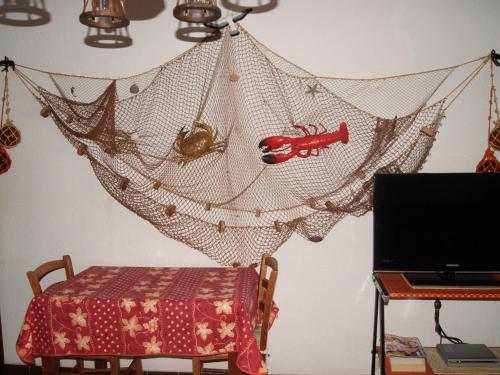 un filet suspendu à un mur avec une table dans l'établissement Studio climatisé pour 4 personnes à 500m de la mer - FR-1-475-173, à Saintes-Maries-de-la-Mer
