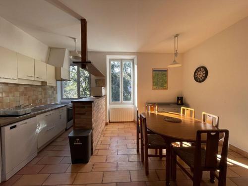 une cuisine avec une table en bois et une salle à manger dans l'établissement Appartement T3 en Ardèche avec animaux admis - FR-1-382-221, à Vallon-Pont-dʼArc
