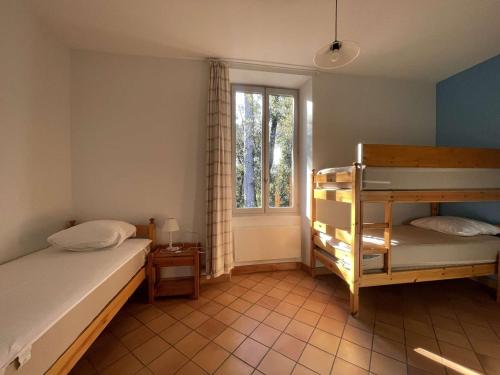 une chambre avec deux lits superposés et une fenêtre dans l'établissement Appartement T3 en Ardèche avec animaux admis - FR-1-382-221, à Vallon-Pont-dʼArc