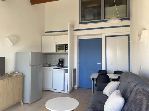 un salon avec un canapé et une table et une cuisine dans l'établissement Duplex 2 pièces avec terrasse et piscine à Balaruc-les-Bains - FR-1-553-300, à Balaruc-les-Bains