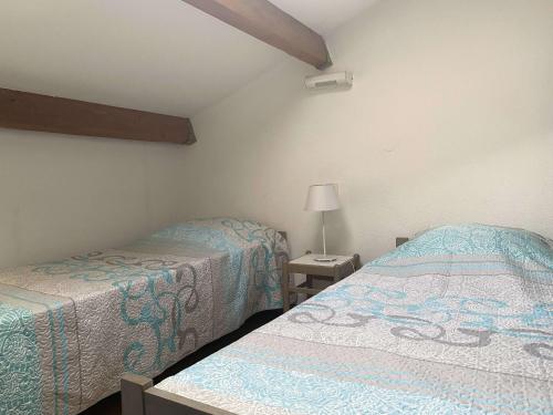 une chambre avec deux lits et une lampe dans l'établissement Duplex 2 pièces avec terrasse et piscine à Balaruc-les-Bains - FR-1-553-300, à Balaruc-les-Bains