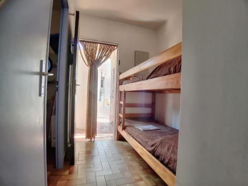 Cette chambre comprend 2 lits superposés et une porte. dans l'établissement Studio 4 pers avec Parking aux Saintes-Maries-de-la-Mer - FR-1-475-176, à Saintes-Maries-de-la-Mer