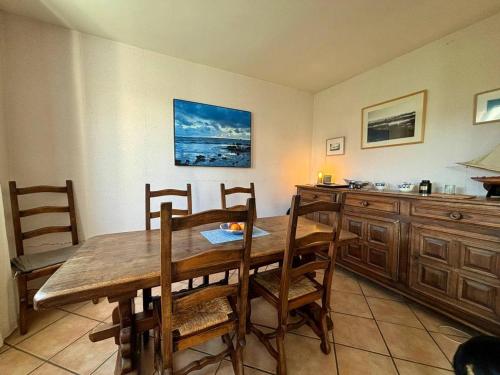 une salle à manger avec une table et des chaises en bois dans l'établissement Maison à Carnac de 4 pièces, 6 personnes, Jardin & Wifi - FR-1-377-98, à Carnac