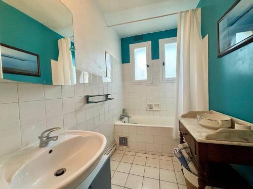a bathroom with a sink and a bath tub at Maison à Carnac de 4 pièces, 6 personnes, Jardin & Wifi - FR-1-377-98 in Carnac