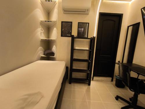 a room with a bed and a shelf and a door at Praia do Bessa, Caribessa - Quarto Privativo - Conforto, Paz e Sossego, excelente para descansar, trabalhar ou estudar in João Pessoa