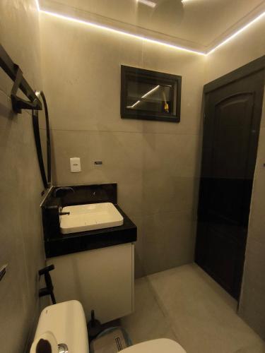 a small bathroom with a toilet and a sink at Praia do Bessa, Caribessa - Quarto Privativo - Conforto, Paz e Sossego, excelente para descansar, trabalhar ou estudar in João Pessoa