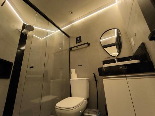 a bathroom with a toilet and a mirror at Praia do Bessa, Caribessa - Quarto Privativo - Conforto, Paz e Sossego, excelente para descansar, trabalhar ou estudar in João Pessoa