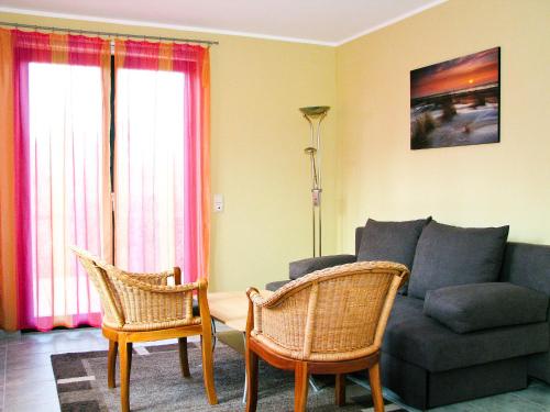 a living room with a couch and two chairs at Hütigendachs, FW 4 in Zingst
