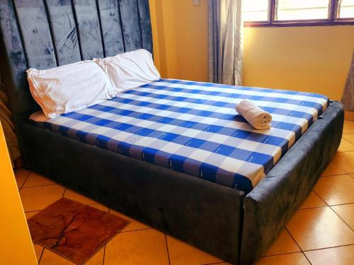 a bed with a blue and white checkered mattress at 2bdrm Mombasa comfy in Mombasa