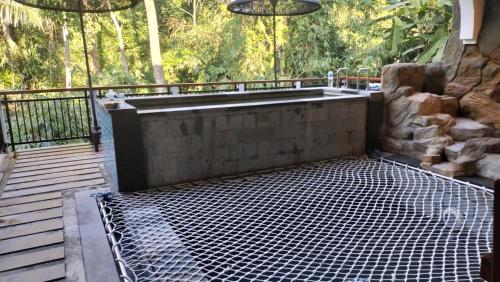 a bath tub sitting on top of a wooden deck at Baruna Sari Villa in Ubud