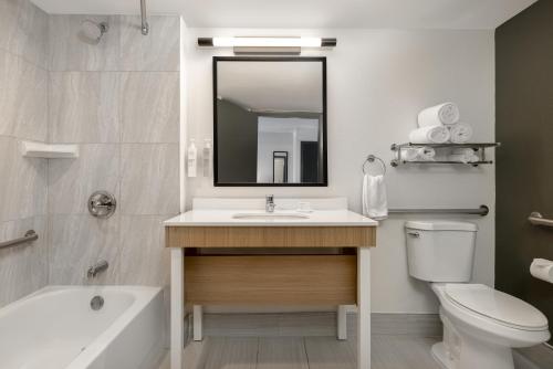 a bathroom with a sink and a toilet and a mirror at Spark by Hilton Rock Springs in Rock Springs