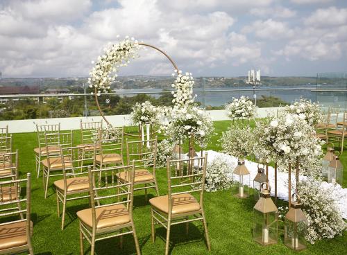 an outdoor wedding ceremony with chairs and flowers at Platinum Hotel Jimbaran Beach Bali in Jimbaran