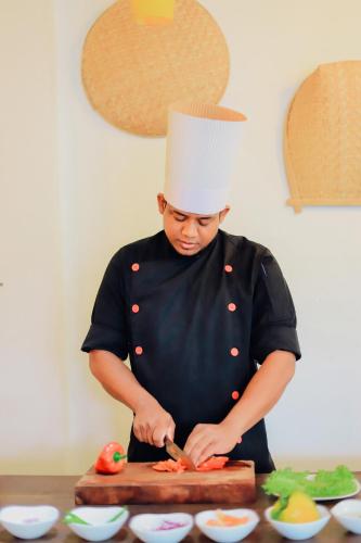 a chef cutting up vegetables on a cutting board at Hidden Gem Yala in Tissamaharama