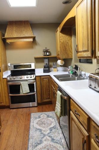 a kitchen with wooden cabinets and a stove and a sink at Whole House at Eaglenest Inn with Pool & SPA in Julian