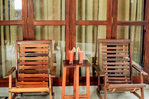 two chairs and a table with two red cups on it at Hidden Gem Yala in Tissamaharama