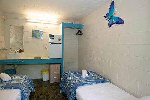 a bathroom with two beds and a butterfly on the wall at CStay in Picnic Bay