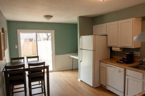 a kitchen with a white refrigerator and a table and chairs at Near KYLE! - Gorgeous Georgia Getaway in College Station