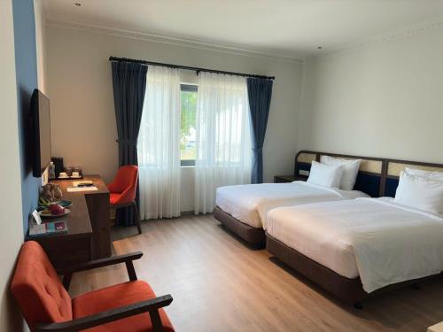 a hotel room with two beds and a chair at Edensee Kega Beach Resort in Ke Ga