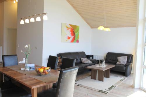una sala de estar con una mesa y un sofá en "Ferienhaus I - Hof Westensee", en Grömitz