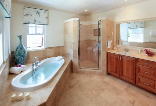 ein großes Bad mit einer Badewanne und einer Dusche in der Unterkunft Royal Westmoreland, Mahogany Drive 7 by Island Villas in Saint James