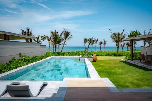 a swimming pool with a view of the ocean at The Ocean Resort by Fusion Quy Nhon in Quy Nhon