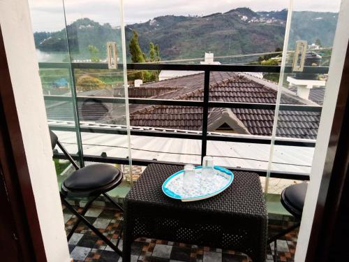 a table and chairs on a balcony with a view at Private 3BHK Villa with a Parking, Garden, WiFi, Mountain View in Kodaikānāl