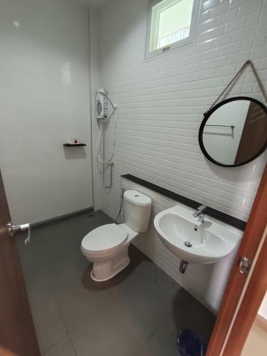 a bathroom with a white toilet and a sink at Good Nine Resort in Ban Lam Kaen