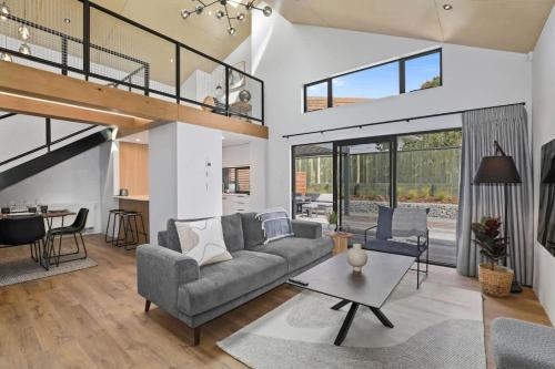 a living room with a couch and a table at Serenity on Sophia in Rotorua