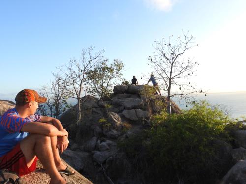 a man sitting on top of a rocky mountain at CStay in Picnic Bay