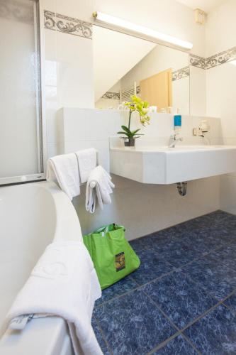 a bathroom with a sink and a green bag at Park Resort in Willingen
